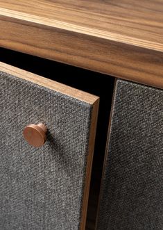 a close up of a wooden cabinet with two drawers and a door handle on it