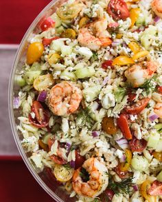 a bowl filled with rice, shrimp and veggies on top of a table