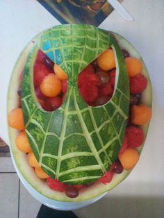 a watermelon carved to look like a face with fruit in it