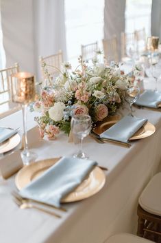 a table set with place settings and flowers