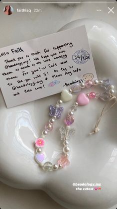 a white plate topped with lots of charms and a note attached to the end of it