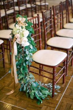 the chairs are decorated with greenery and flowers