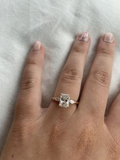 a woman's hand with a ring on it and a diamond in the middle