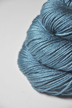 a skein of blue yarn on a white surface