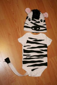 a baby zebra onesuit and hat are laying on the floor