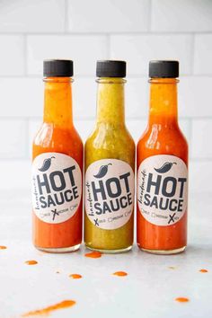 three bottles of hot sauce with the words homemade hot sauce on them and an orange text that reads easy holiday gift