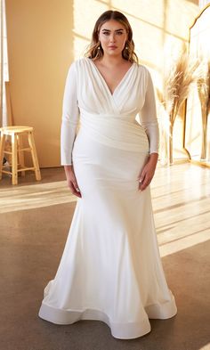 a woman in a white dress posing for the camera with her hands on her hips