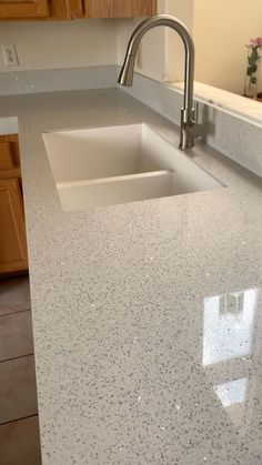 a kitchen counter top with a sink and faucet in the middle of it