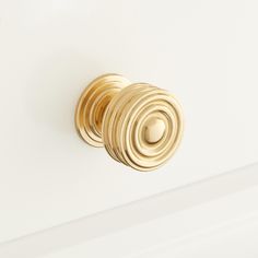 an image of a golden door knob on a white wall