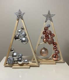 two wooden christmas trees with ornaments on them