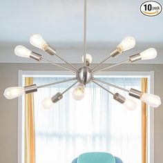 a living room with a blue chair and a chandelier hanging from the ceiling