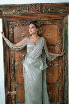 a woman in a white sari posing for the camera