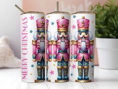 two pink and blue nutcrackers with stars on them are next to a potted plant