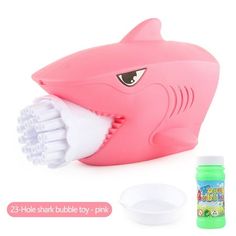 a pink shark toothbrush holder with its mouth open and two containers next to it