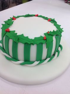 a green and white decorated cake sitting on top of a table