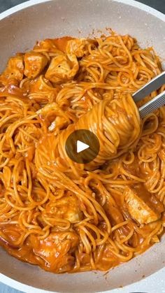 a pan filled with noodles and sauce being stirred