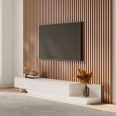 a modern living room with a flat screen tv mounted on the wall and a vase in front of it