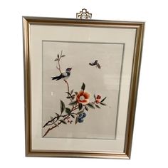 a framed painting with flowers and birds on it