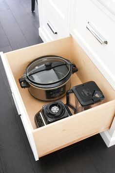 an open drawer in a kitchen with pots and pans