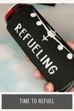 a person holding a black bottle with the words refilling on it and an airplane in the background