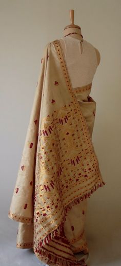 "This is hundred percent authentic Muga Silk Saree . It has Muga silk in the warp and weft . The interwoven motif yarns are in Guna ( golden zari ) and Acrylic. The design is traditional and can be considered as bridal . Muga Silk - The most valued silk from India. Almost exclusively reared and produced in Assam, India. It is indigenous to the Brahmaputra Valley and assiduously practiced in the districts of Assam. The moth is basically a wild moth. Hence it is categorised as Vanya Silk or Wild s Luxury Cotton Silk Saree With Gota Work, Luxury Traditional Silk Scarf With Zari Work, Luxury Tussar Silk Pre-draped Saree With Dupatta, Luxury Handloom Dola Silk Traditional Wear, Luxury Jamawar Traditional Wear With Zari Weaving, Luxury Bohemian Katan Silk Saree, Gold Embroidered Silk Fabric With Motifs, Gold Silk Dupatta With Woven Motifs, Festive Gold Embroidered Fabric With Zari Weaving