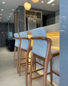 a row of bar stools sitting next to a counter in a room with lights on