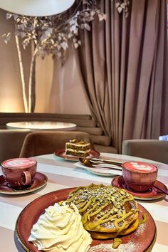 a table topped with plates of food and cups of coffee