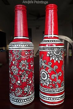 two red and white vases sitting on top of a wooden table next to each other