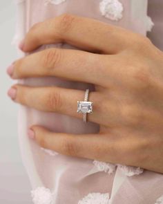 a woman's hand wearing a diamond ring