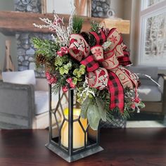 a christmas centerpiece on a table with a candle