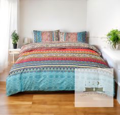 a bed with colorful comforter and pillows in a room