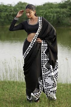 Black saree in taffeta base with black and white prism print on the pallu. Paired with long sleeves embellished neckline padded blouse.
Components: 2
Pattern: Print
Type Of Work: Prism
Neckline: Scoop
Sleeve Type: Full
Fabric: Taffeta
Color: Black
Other Details: 
Attached lining
Padded blouse
Model height: 5ft 8inches, wearing size S
Length:
Blouse: 14inches
Saree: 45inches
Disclaimer: This product is exclusively hand crafted using multiple techniques, individually handled at different stages, a Sarees Black, White Satin Blouse, Padded Blouse, Embellished Neckline, Black Saree, Blouse Models, Blouse For Women, Black N White, Saree With Blouse