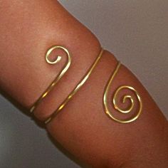 This armlet has been created using thick 12 gauge brass. This armlet wraps twice around the arm and is adorned with a small swirl on the top and a larger swirl on the bottom. ♥These are available in brass, bronze, copper and German silver. Please note that German silver contains nickel and contains no silver, but is lead free. Please Note: When measuring your lower arm for this piece...be sure the size you choose is the thickest part of the arm it will sit, as this piece is slightly tapered. if Handmade Flexible Gold Bracelet, Gold Handmade Flexible Bracelet, Wire Wrapped Gold Bracelets For Festival, Gold Wire Wrapped Bracelets For Festivals, Gold Wire Wrapped Bracelet For Festival, Upper Arm Jewelry, Upper Arm Bracelet, Gold Arm Cuff, Gold Arm Band