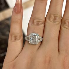 a woman's hand with an engagement ring on it and a diamond in the middle