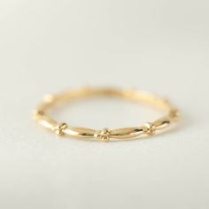 14k solid gold unique wedding band perfect for stacking. Pair this dainty ring with any other simple ring or engagement ring. The design goes all around the band. Will make a great addition to your everyday stack. Purchase this beautiful piece for special occasions such as birthdays, anniversaries, Christmas, Mother's Day, Valentine's Day, or even for bridesmaids! * Band size: 1.5mm wide x 1.2mm tall * Made of 100% recycled precious metal * Comes in a gift box with a bow ready for gifting * Hand Baguette Wedding Rings, Dainty Wedding, Dainty Wedding Ring, Paper Ring, Zierlicher Ring, Ring Stack, Unique Wedding Bands, Emerald Engagement Ring, Recycled Metal