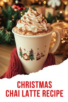 a cup of hot chocolate with whipped cream on top and christmas decorations in the background