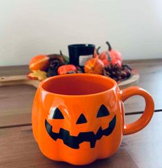 an orange pumpkin mug sitting on top of a wooden table