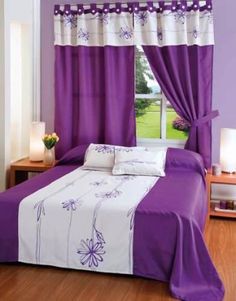 a purple and white bed in a bedroom next to a window with flowers on it