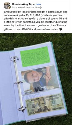 an open book sitting on top of a lush green grass covered field next to a pile of money