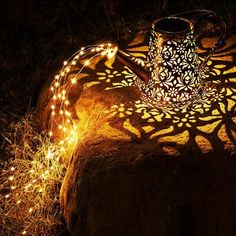 a light that is sitting on top of a rock in the dark with some lights around it