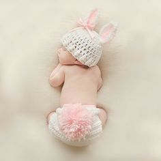 a baby is wearing a crocheted bunny hat and diaper