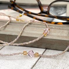 Sparkly eyeglass necklace chain made with Preciosa Czech crystal seed beads in golden tones with delicate multicolor flashes, featuring gold and pink cubic zirconia beads. Unique and bohemian this necklace chain will definitely create a unique look.   This eyeglass lanyard is made on strong quality beading wire with gold plated wire guardians that protect the quality eyeglass holder grips. The necklace is ended with spring clasps that hold the eyeglass grips and they can be easily removed to tra Adjustable Crystal Necklaces With Colorful Glass Beads, Gold Beaded Glass Crystal Necklaces, Adjustable Gold Crystal Glass Necklace, Gold Glass Necklaces With Colorful Beads, Gold Necklace With Colorful Glass Beads, Adjustable Gold Beaded Necklace With Czech Glass, Gold Glasses Chains With Colorful Glass Beads, Bohemian Gold Glasses Chains With Colorful Beads, Bohemian Gold Beaded Glass Necklaces