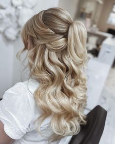 a woman with long blonde hair sitting in a chair