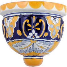 a blue and yellow vase with flowers on it