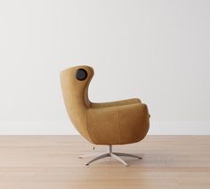 an egg chair sitting on top of a hard wood floor next to a white wall