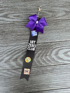 a purple ribbon with the words hit zero club on it hanging from a keychain