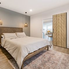 a bedroom with a large bed and wooden headboard on top of a carpeted floor