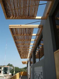 the outside of a building with wooden slats hanging from it's roof line