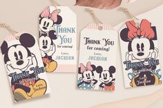 three mickey and minnie mouse thank you tags hanging from clothes pins on a table with other items