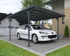 a white car is parked in front of a house with an attached carporture